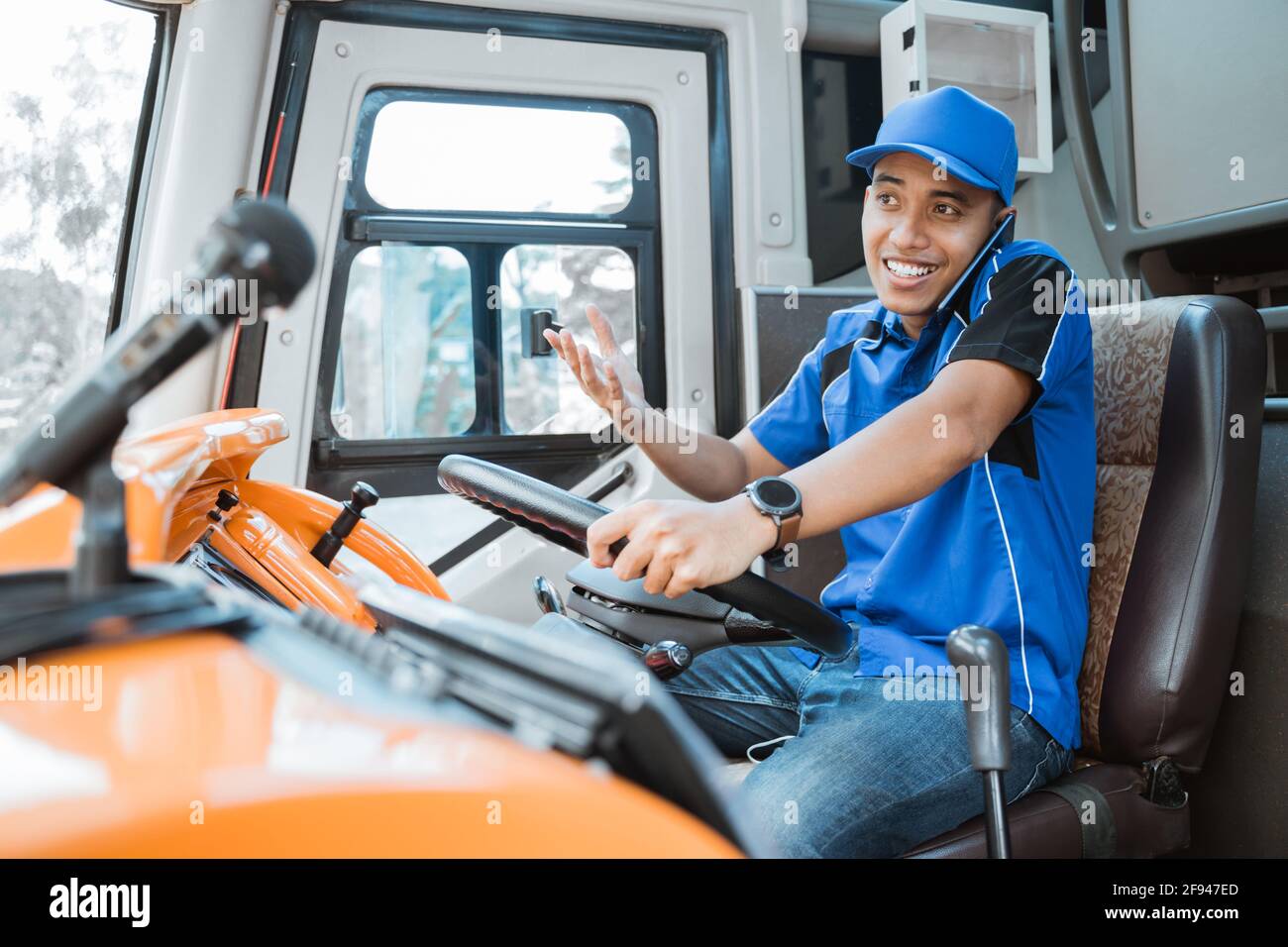 a male driver in uniform with hand gesture when calling while driving Stock  Photo - Alamy