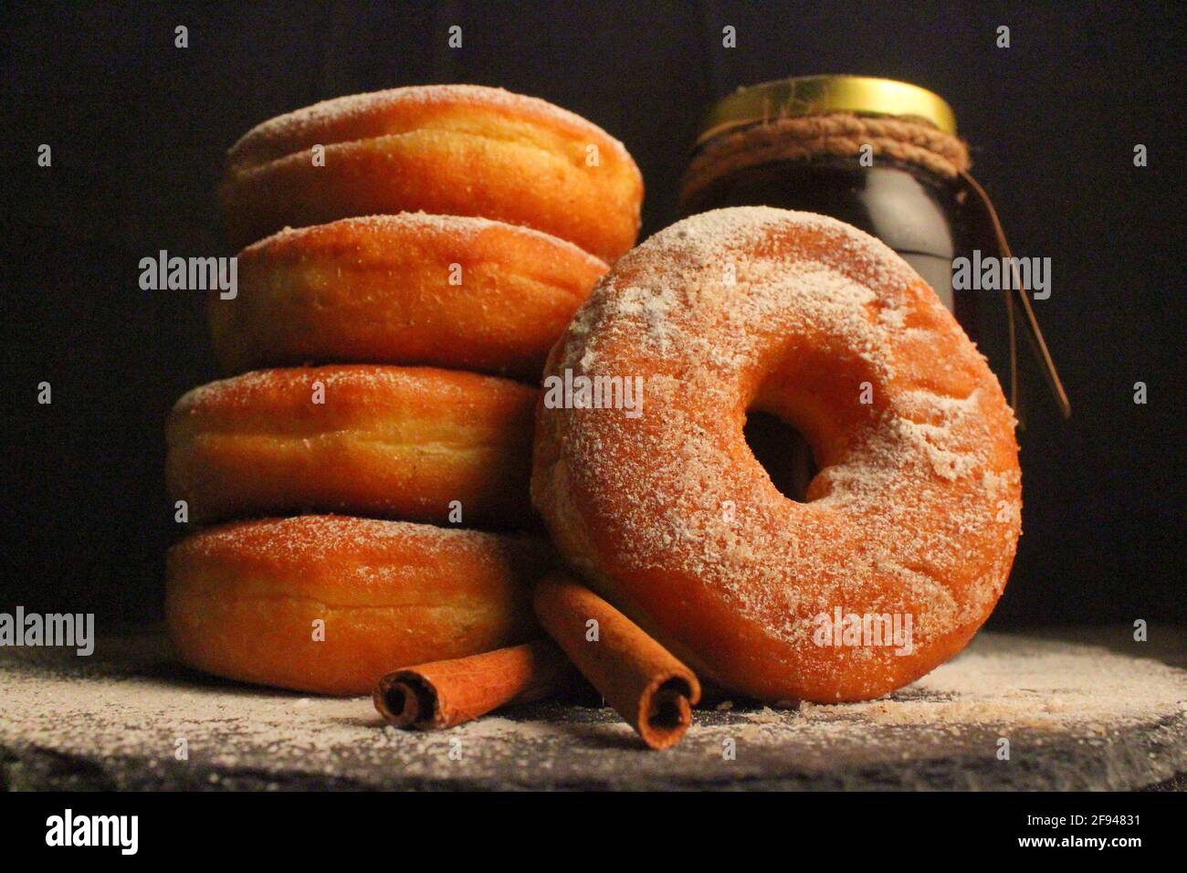 Doughnuts with powdered sugar against dark background, Studio shot Stock Photo