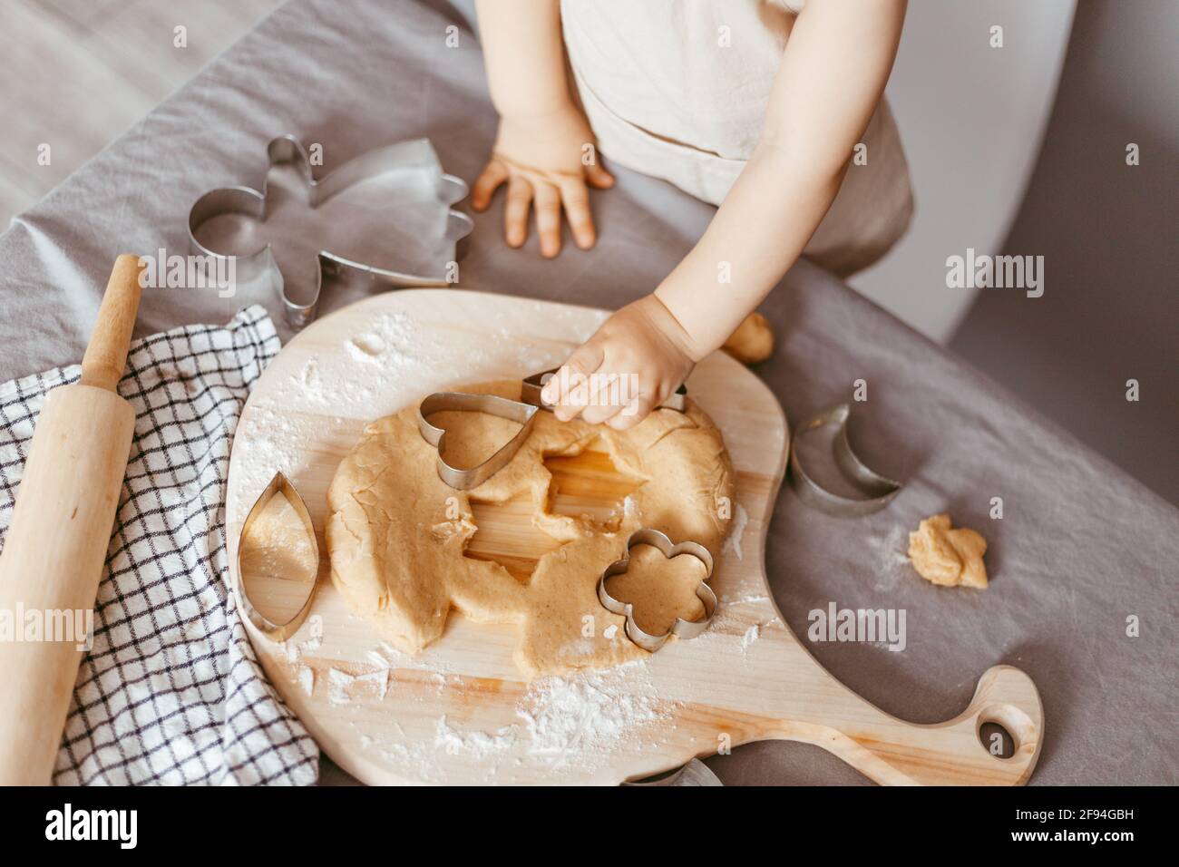Portrait of a little cook kneading dough in an apron and a chef's hat. Cooking children's lifestyle concept Stock Photo