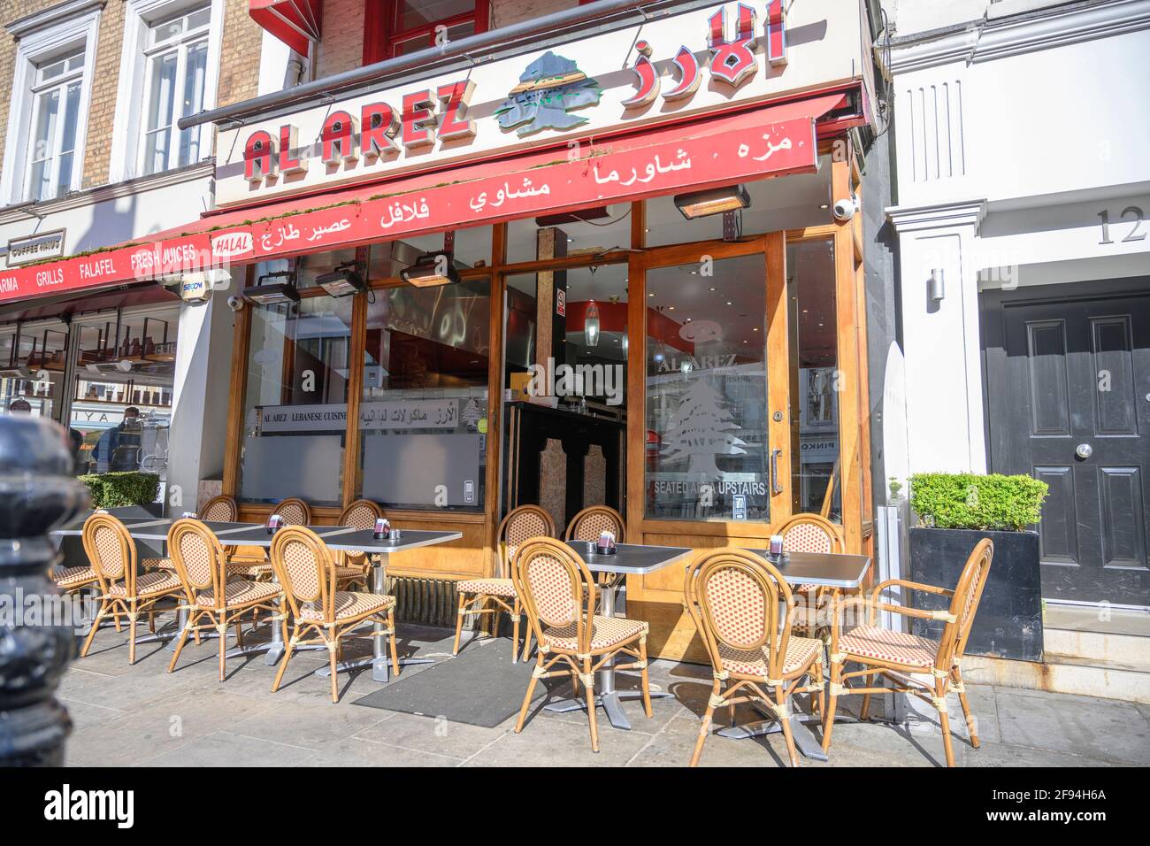 Knightsbridge, London, UK. 16 April 2021. A sunny morning in London though still with relatively low footfall. A Lebanese cafe restaurant tables opposite Harrods remain empty. Credit: Malcolm Park/Alamy Live News. Stock Photo