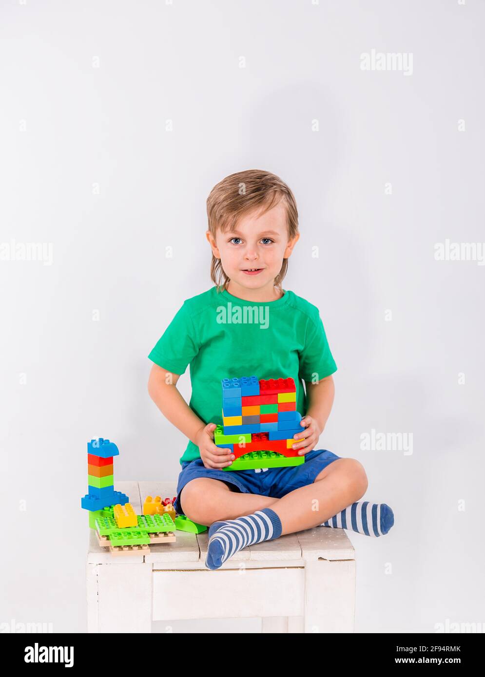 Little boy playing with lots of colorful plastic blocks constructor ...