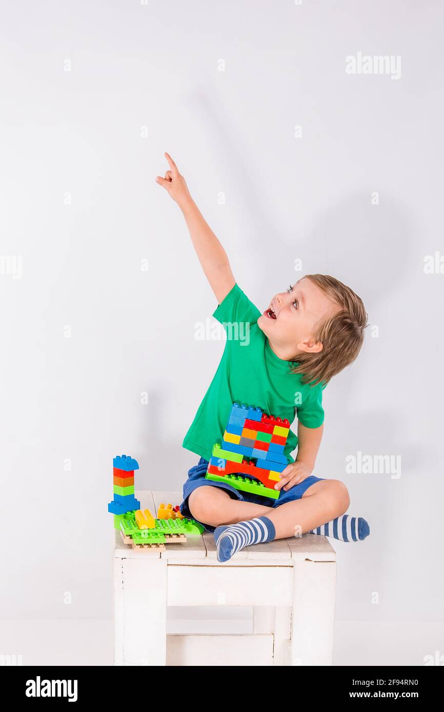 Little boy playing with lots of colorful plastic blocks constructor ...