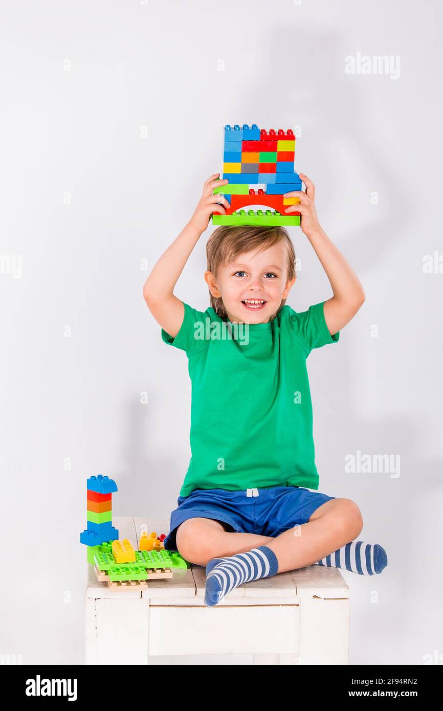 Little boy playing with lots of colorful plastic blocks constructor ...