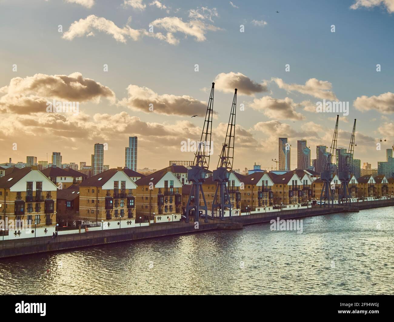London UK Dec 2019- An old dockside, now redeveloped to aspirational residential properties as part of a gentrification project, with a wider city sky Stock Photo