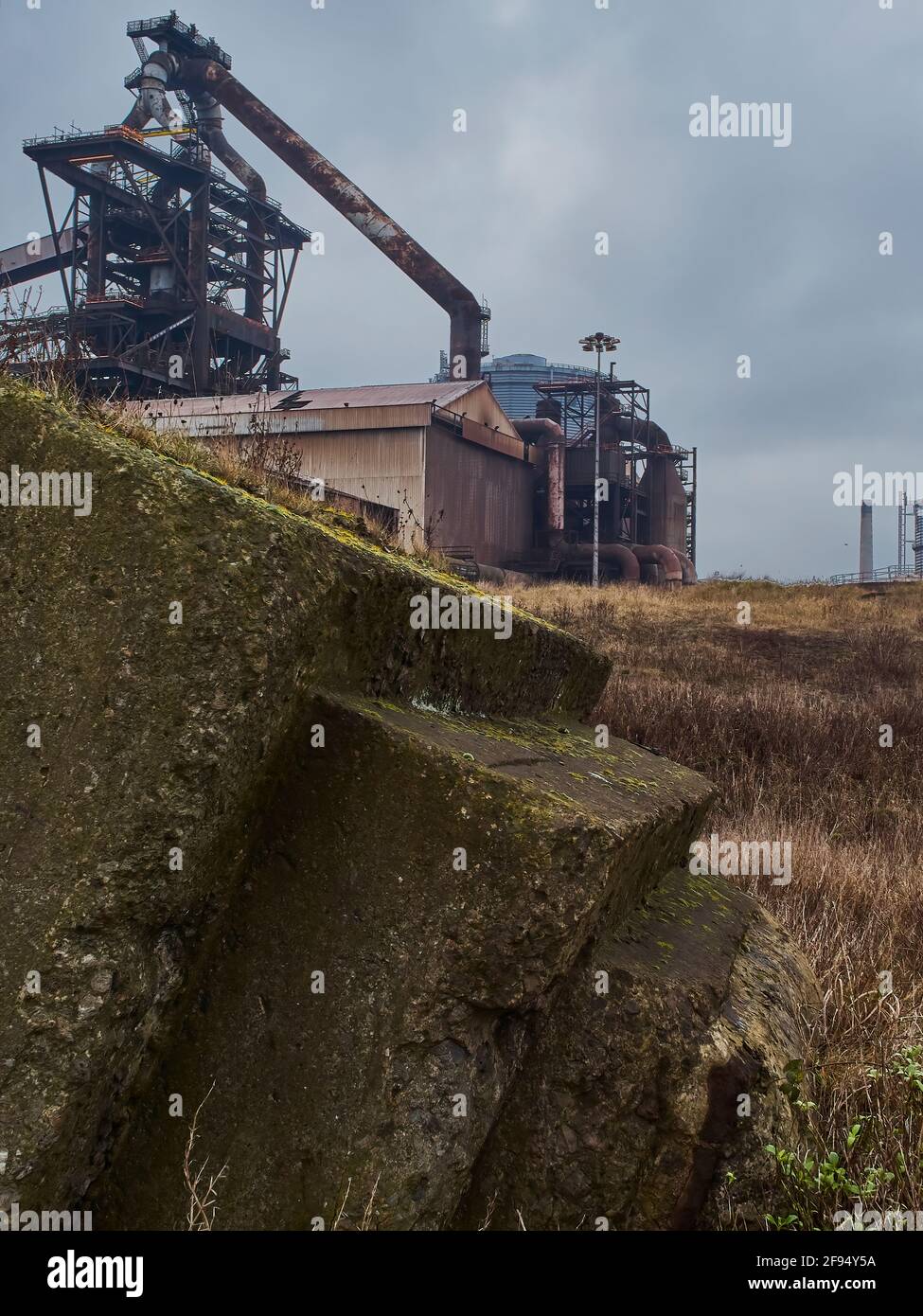 A detail from the abandoned Redcar Steelworks complex, showing the intricate web of support structure for the blast furnace and a rusting workshop. Stock Photo