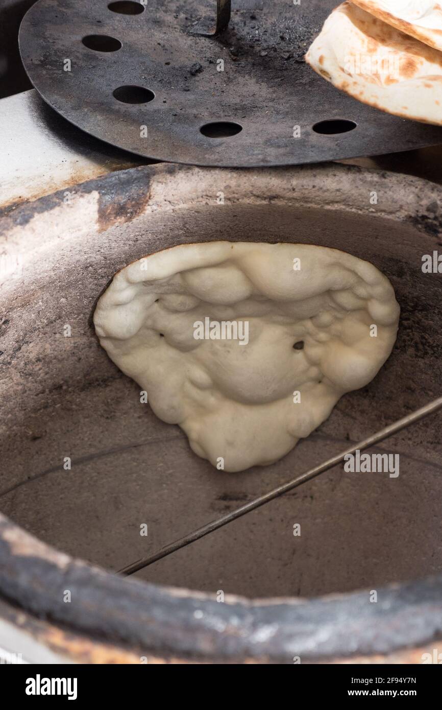 Homemade lavash bread being baked inside a traditional Armenian floor oven  called ´tonir' Stock Photo - Alamy