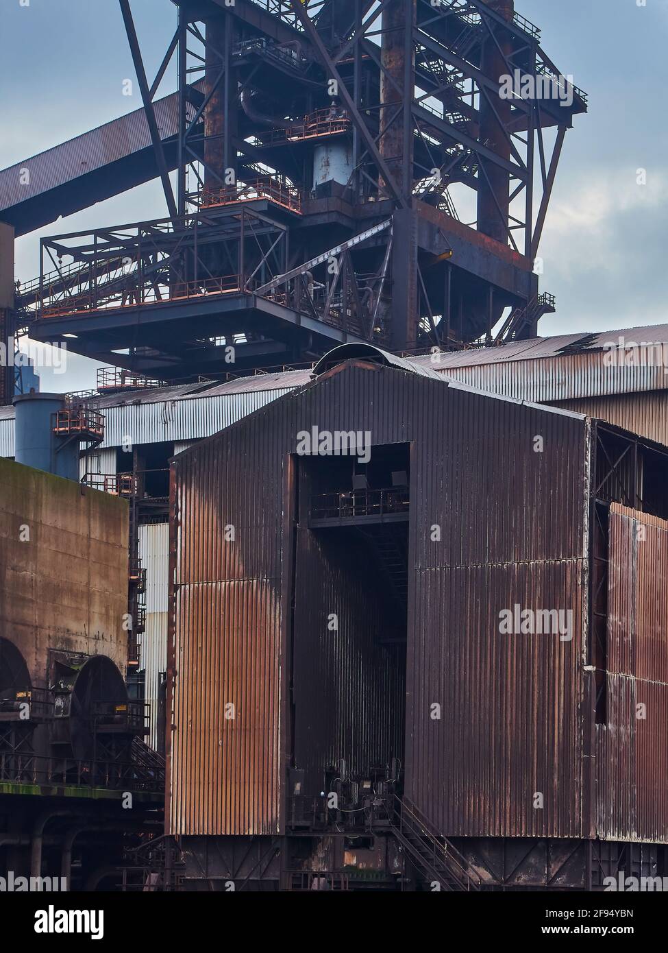 A detail from the abandoned Redcar Steelworks complex, showing the intricate web of support structures for the blast furnace and a rusting workshop. Stock Photo