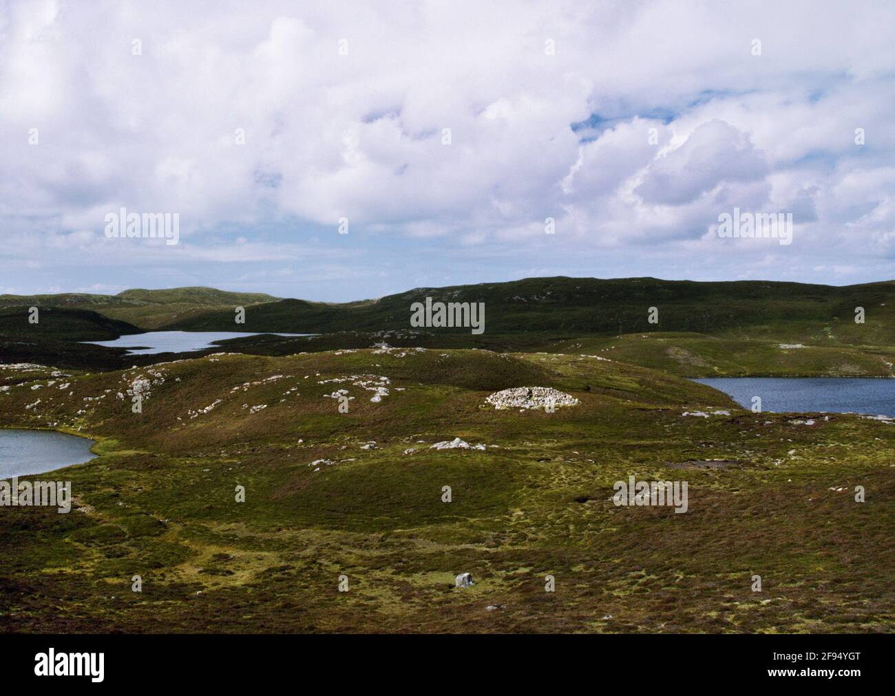 View NW showing Punds Water Neolithic heel-shaped chambered cairn situated on a rocky knoll between lochans on North Mainland, Shetland, Scotland, UK. Stock Photo