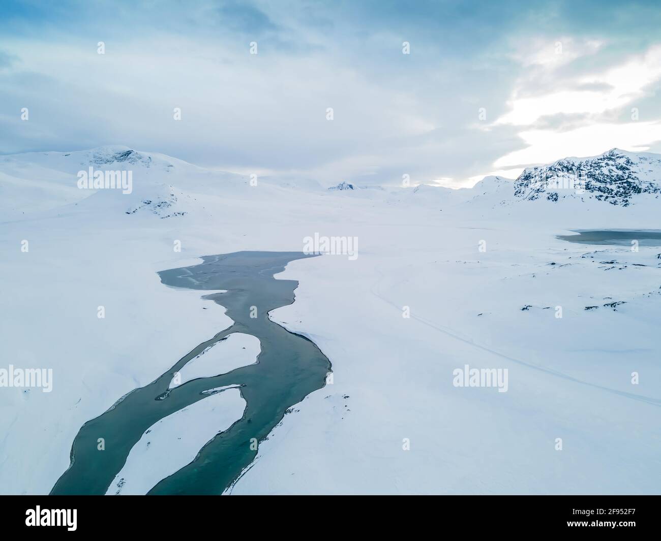Stunning aerial view of a river flowing through a snow covered tundra. Stock Photo