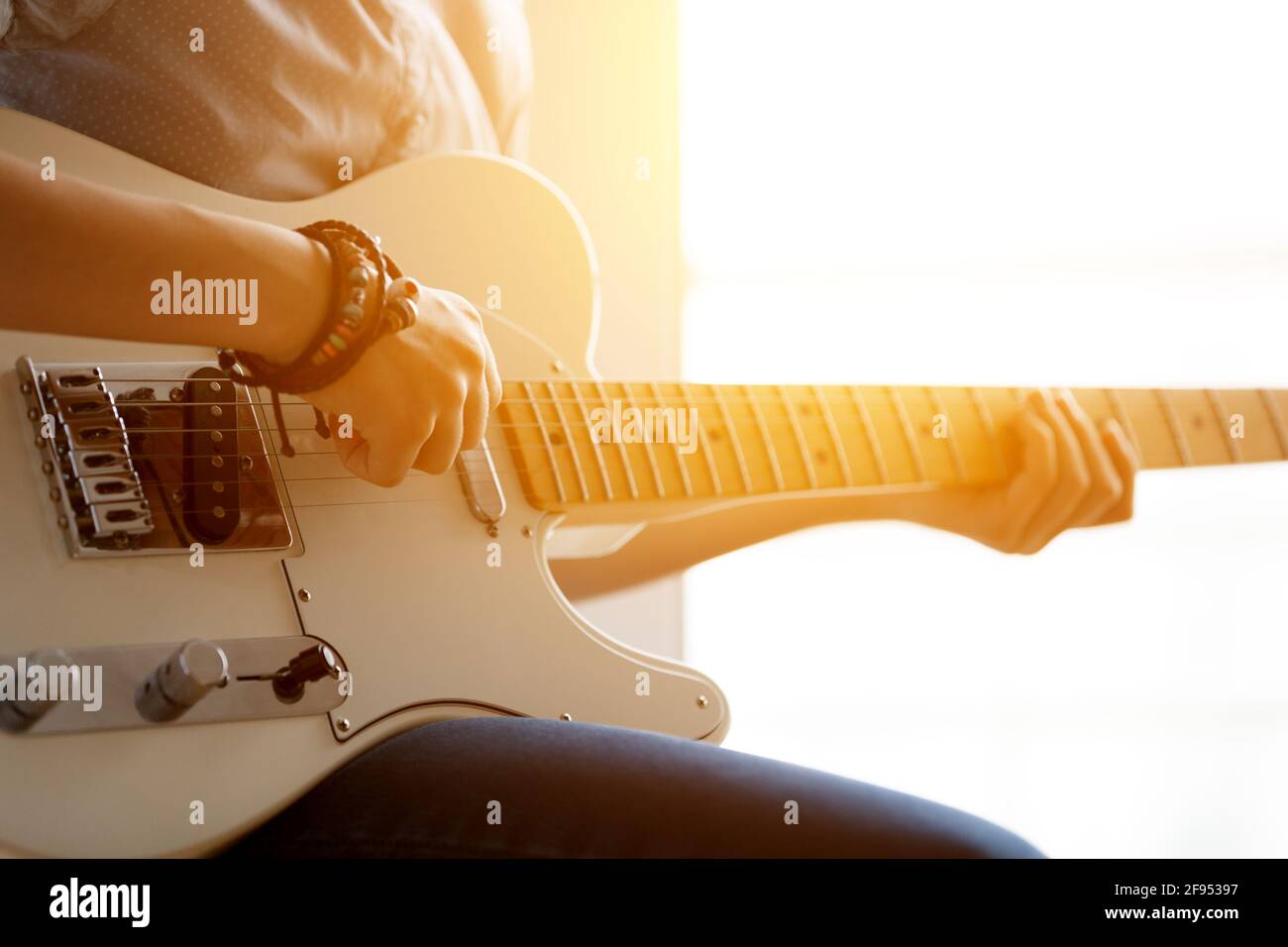 Silhouette of a girl with a guitar near the window. Stock Photo