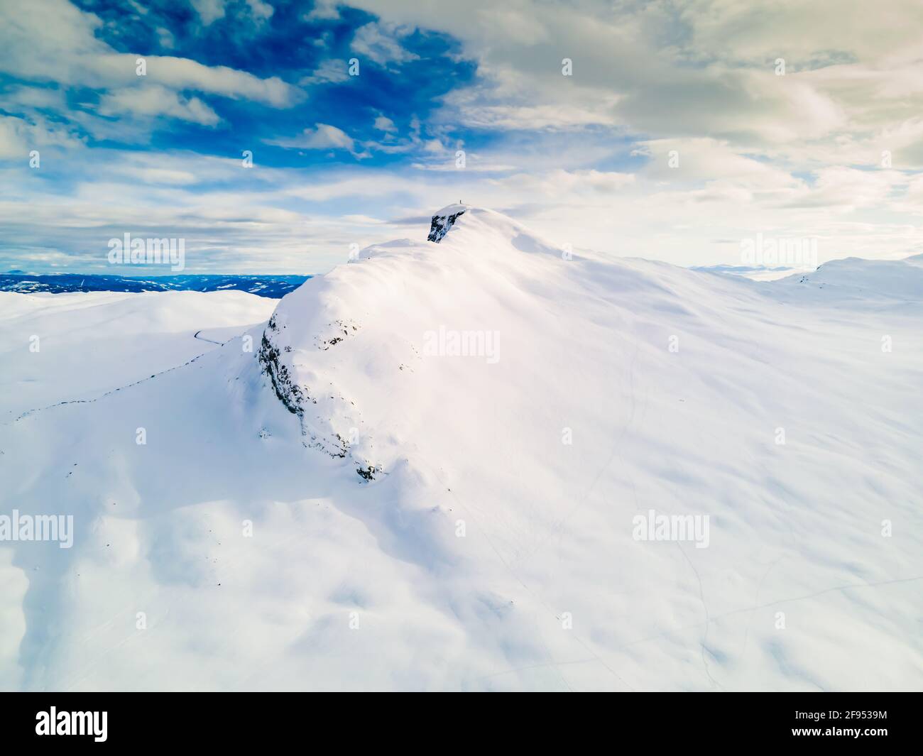 Panoramic view of a snow capped mountain peak with clouds and blue ...