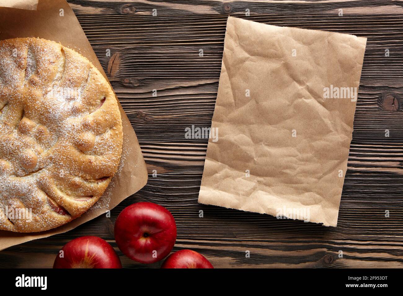 Apple pie on a wooden rustic table. Top view.  Piece kraft paper empty space for text. Stock Photo