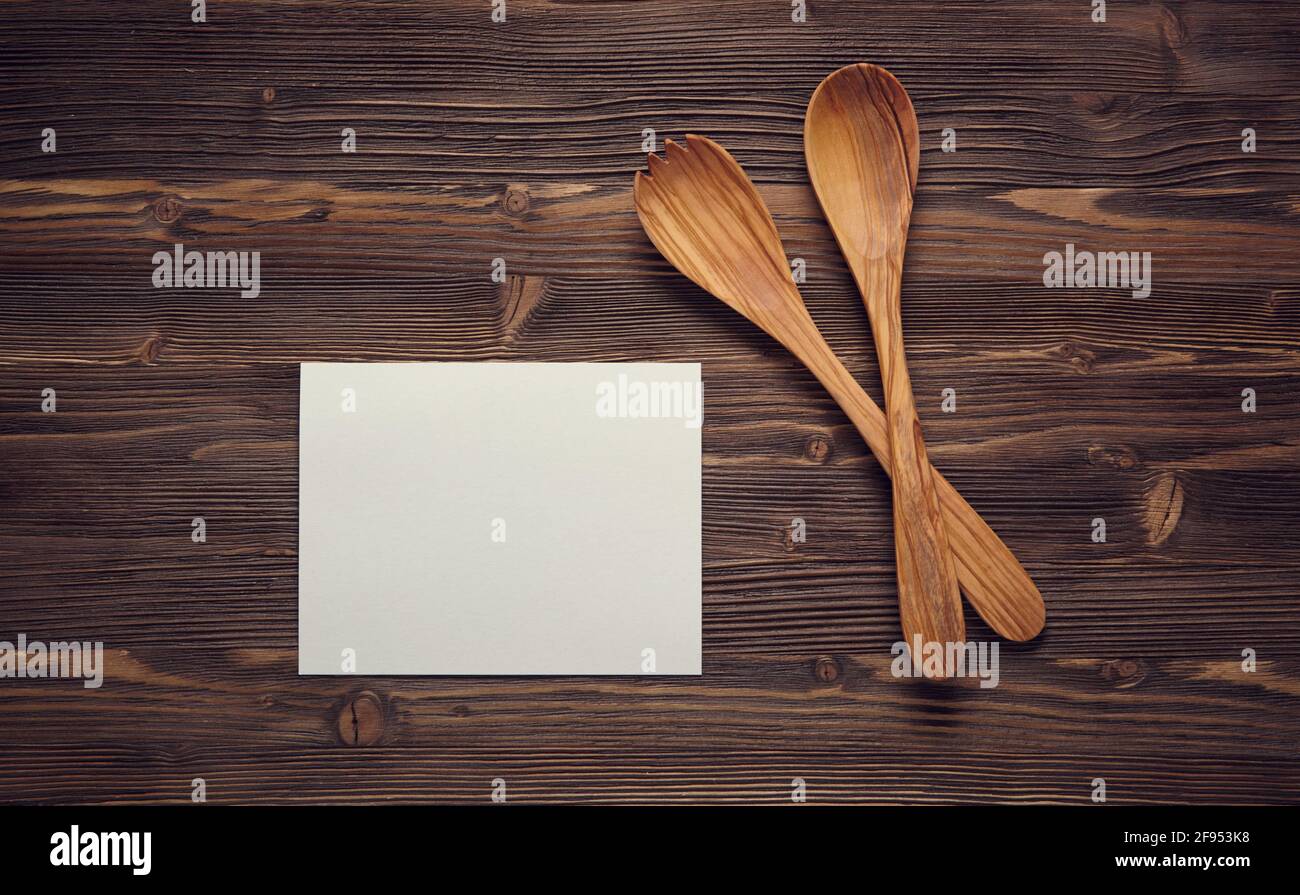 Close up wooden spoons, and blank paper on wooden board. Top view. Stock Photo