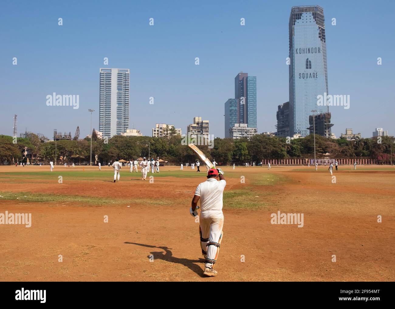 Cricket batsman walking onto the field in Shivaji Park in Mumbai-Dadar, India Stock Photo