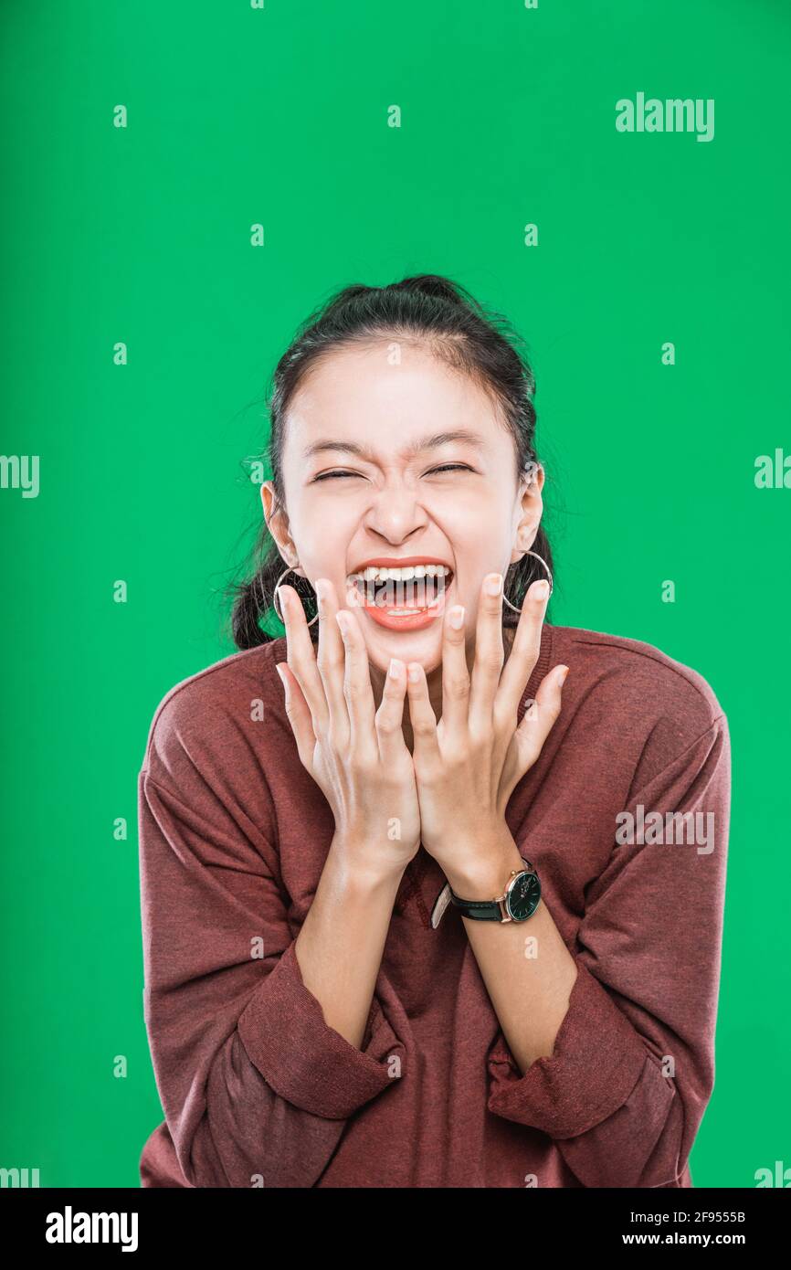 Young Asian Woman Expressing Wide Open Mouth And Raising Hands In