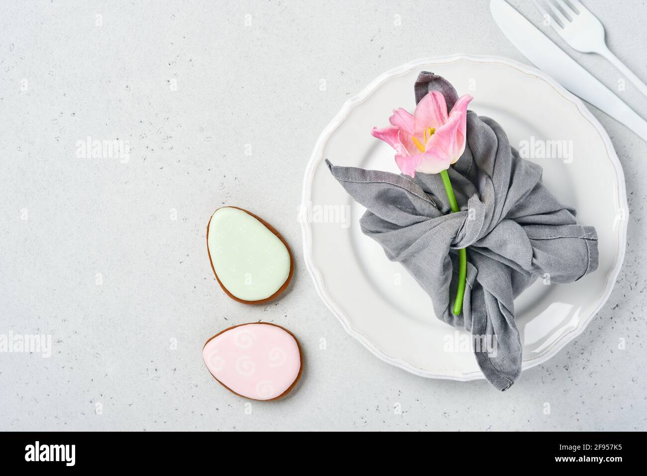 Easter table setting with floral decor on gray table. Elegance dinner. Mock up. Top view. Stock Photo