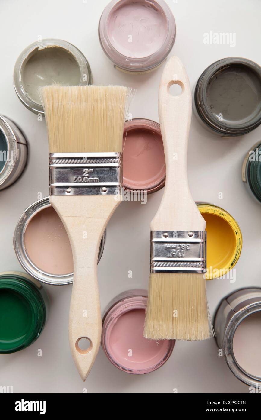 Overhead view of a DIY paint brush with colorful sample paint pots Stock Photo