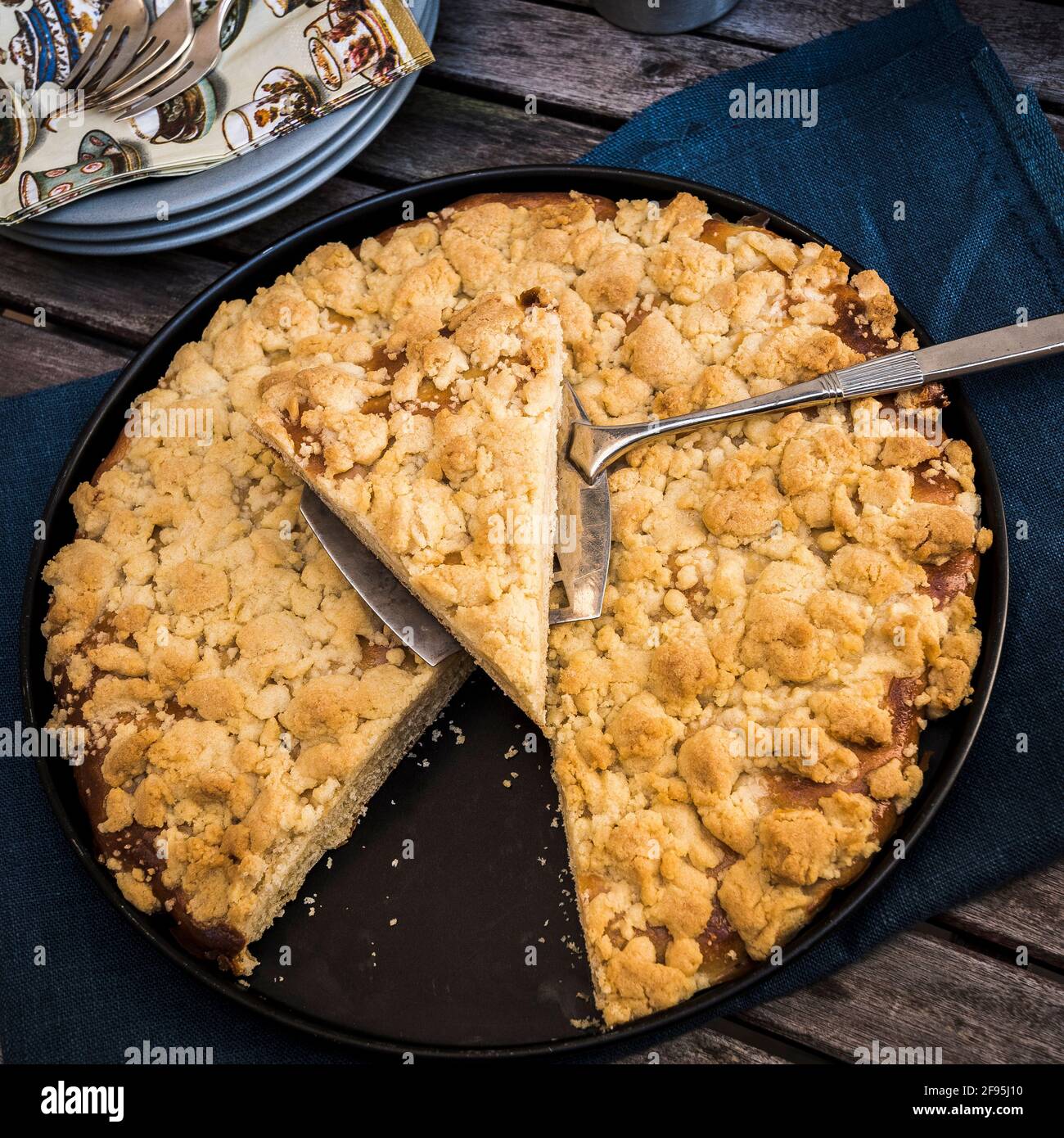 Round crumble pie on a blue napkin on a wooden table Stock Photo