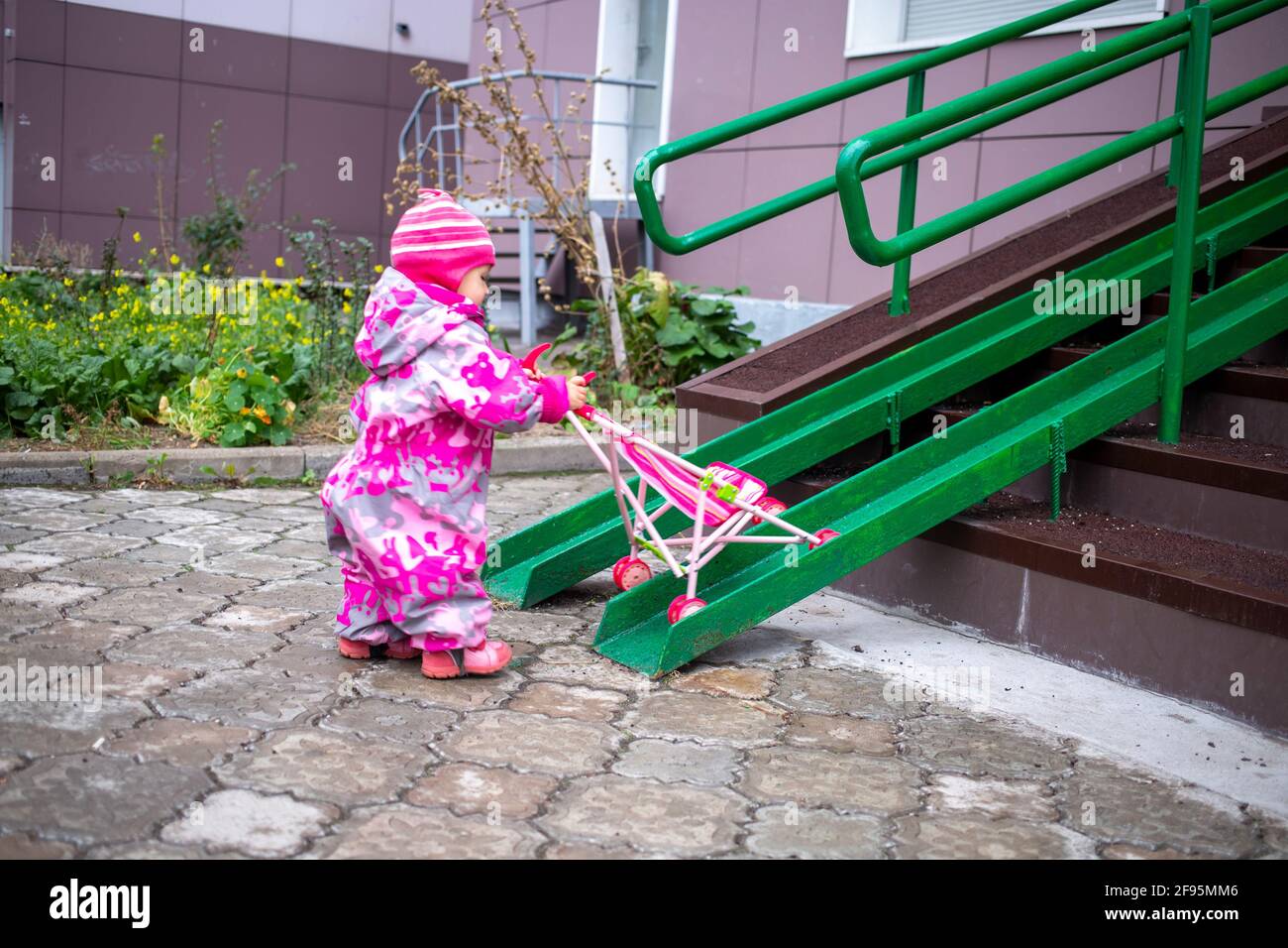 Stroller Railing Ramp cute toddler with a toy stroller walks along steel railing ramp for ...