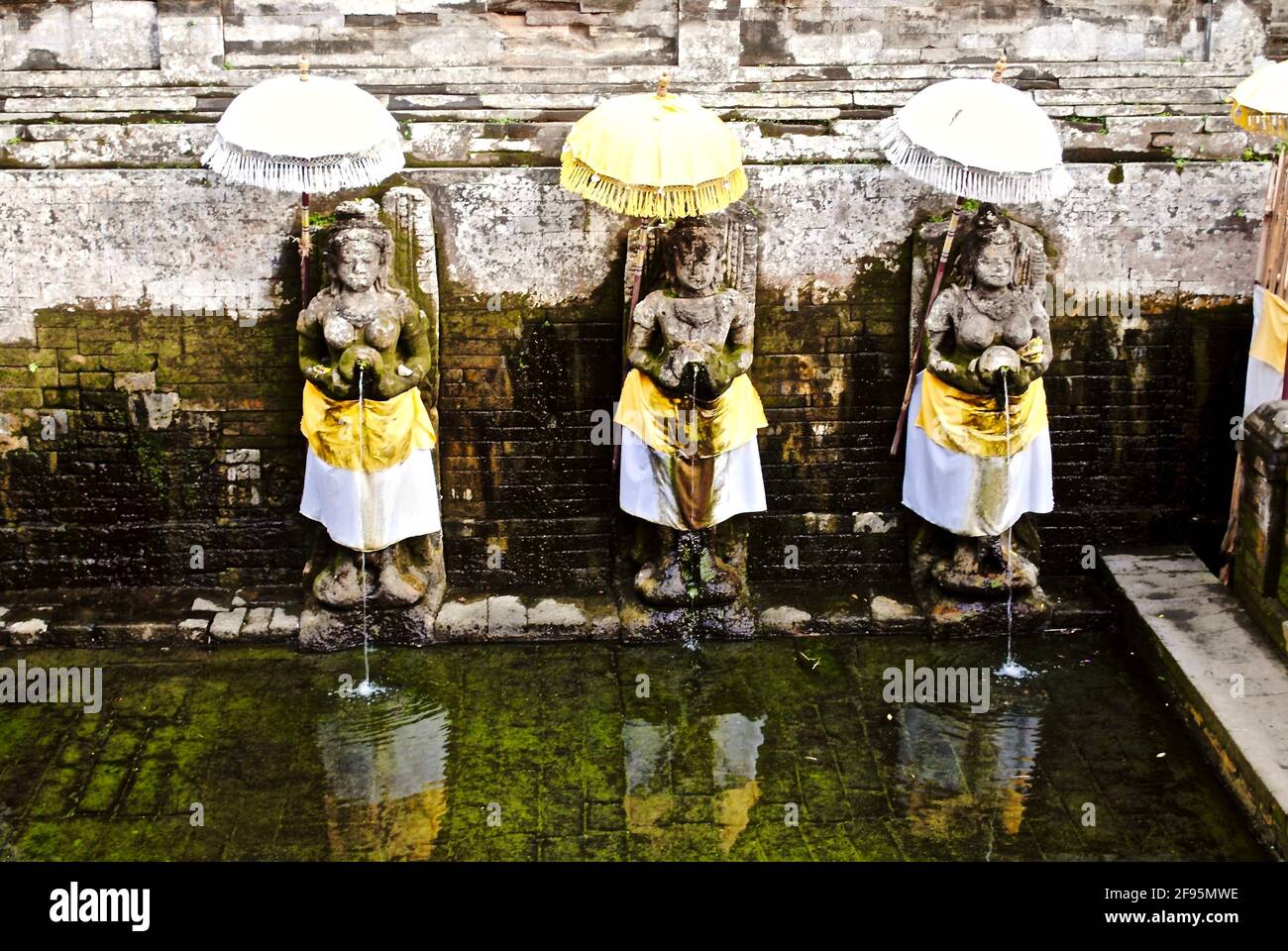 Ubud, Bali, Indonesia: Goa Gajah, or Elephant Cave, sanctuary. Hindu bathing temple statues women with water pitchers that depicts seven holy rivers. Stock Photo