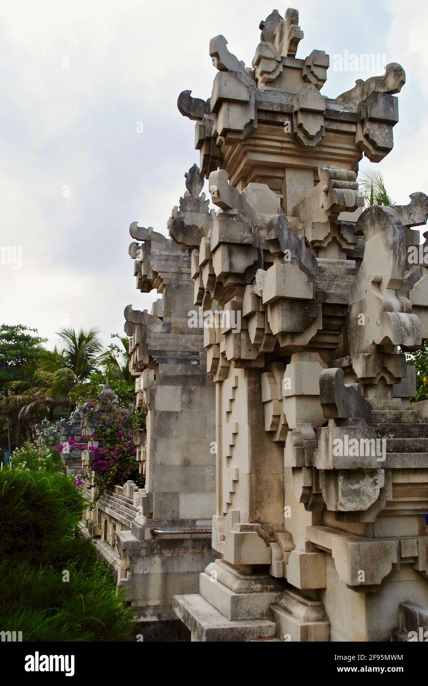 Decorative beach wall and gate in Kuta, Bali, Indonesia. The decorative feature controls beach erosion and evokes traditional Balinese architecture. Stock Photo