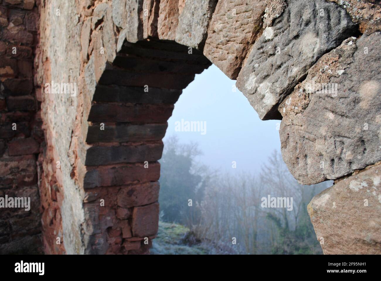LANDSTUHL, GERMANY: Burg Nanstein (Nanstein Castle) in Landstuhl, Germany on a foggy, misty morning. A stone arch with view of the surrounding forest. Stock Photo