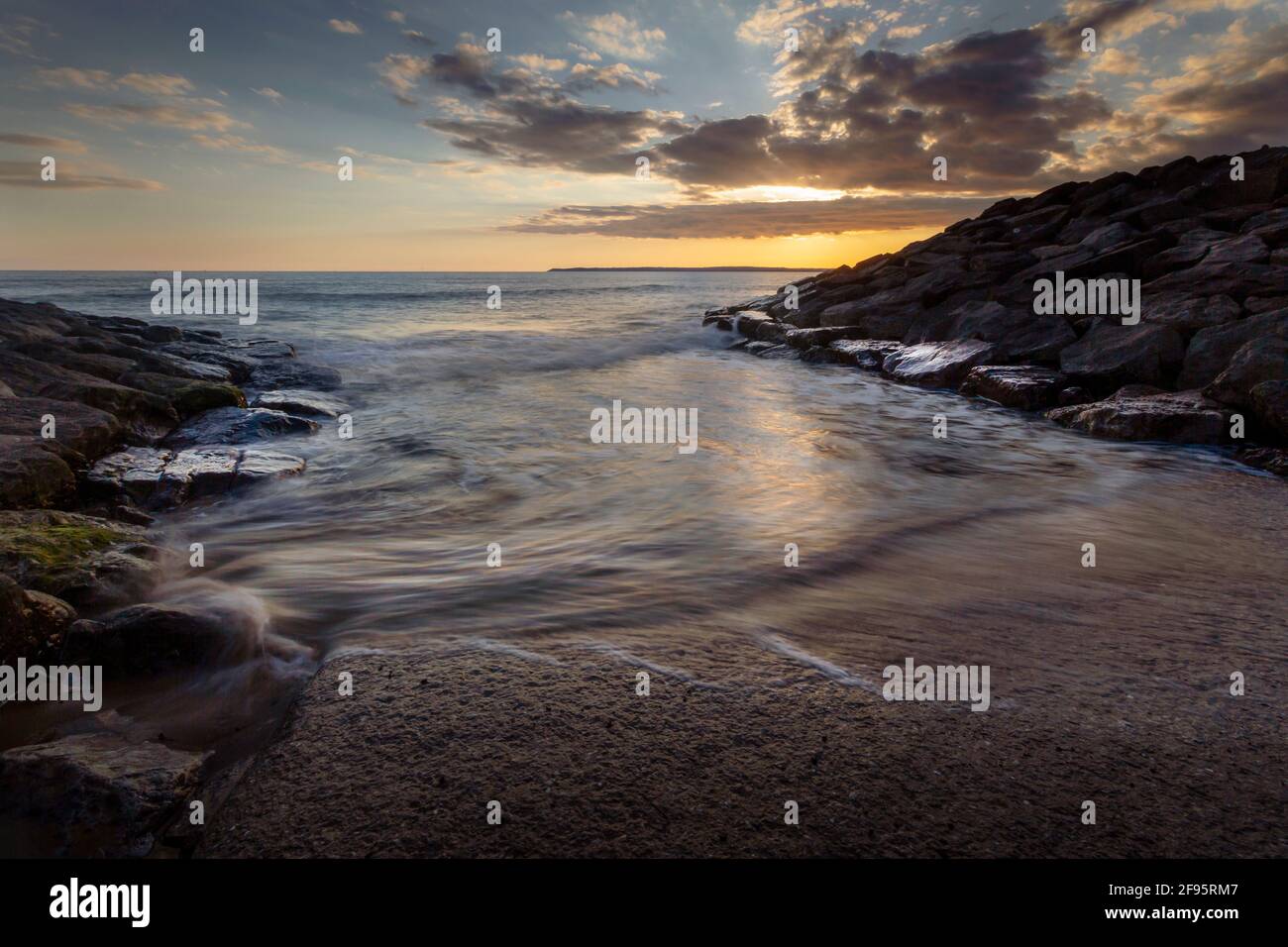 Sunset at Aberavon beach on an incoming tide in Port Talbot, South Wales, UK Stock Photo