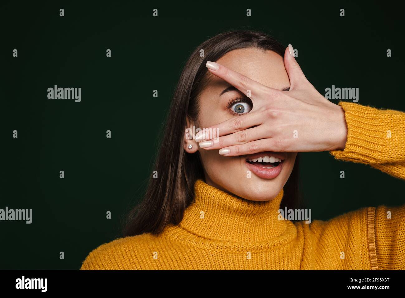 Excited beautiful girl expressing surprise and covering her face ...
