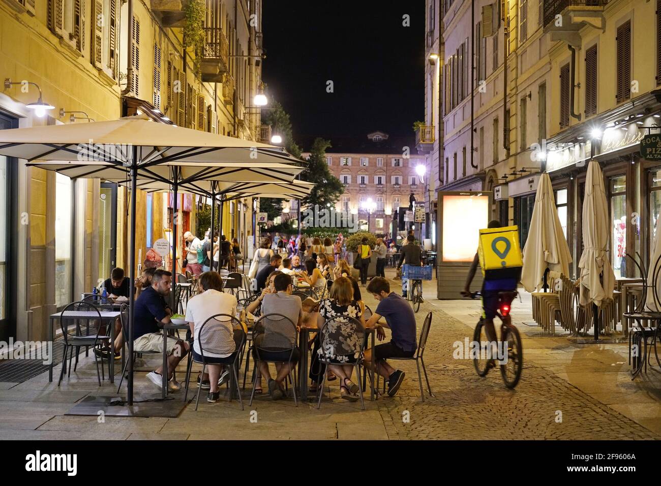 Restaurant reopen. Customers sit at tables in a terrace area outside cafe in Turin, Italy, July 2020. Stock Photo