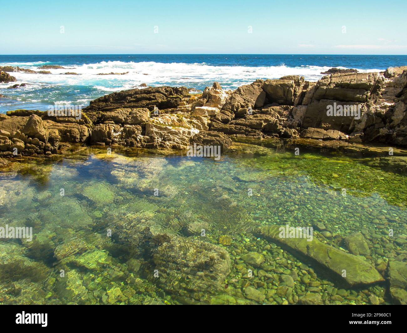 A clear tidal pool, sheltered from the waves, along the rocky Tsitsikamma coast on the southern coast of South Africa Stock Photo