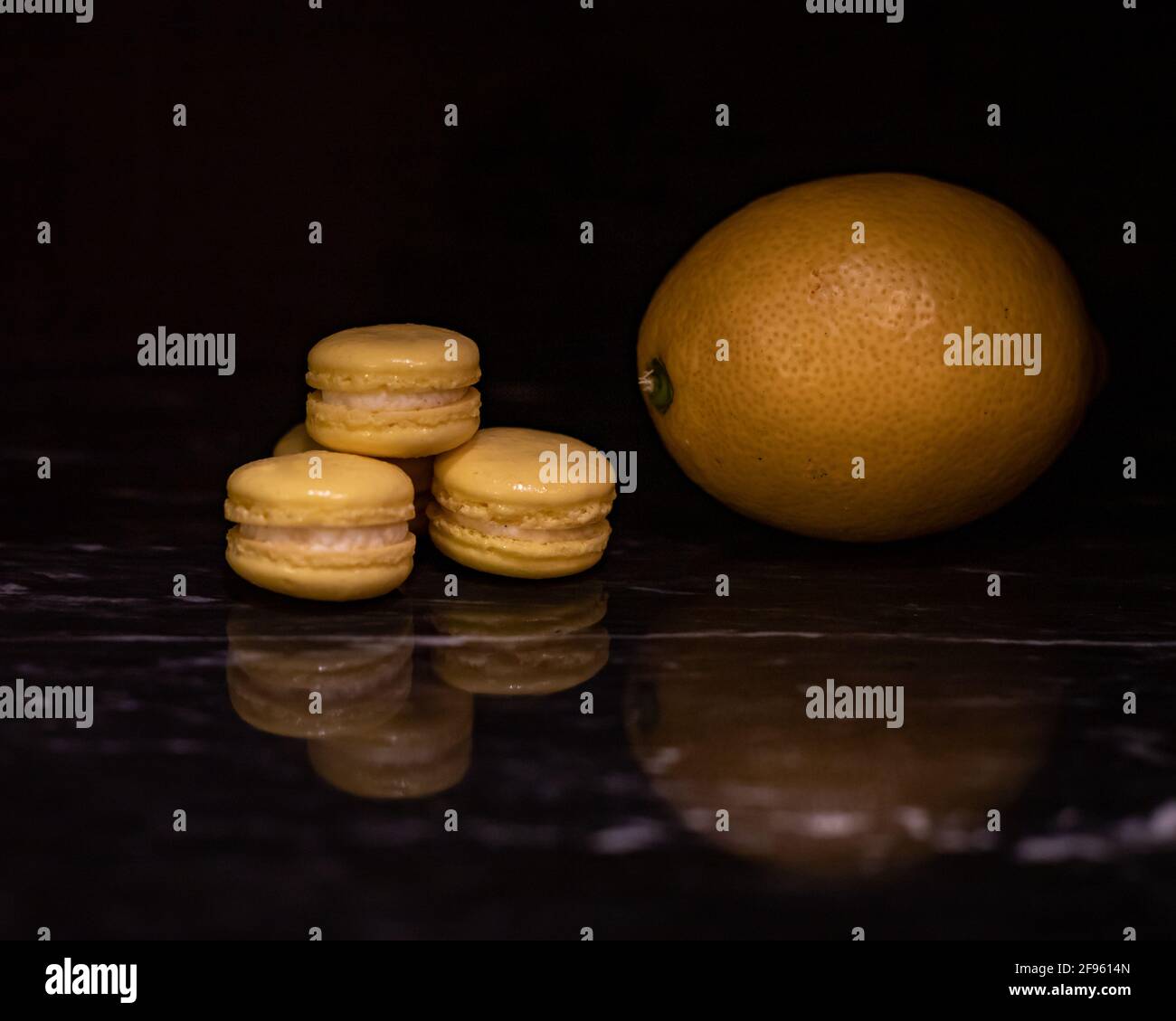 Mini Lemon Macarons on Black Marble Stock Photo