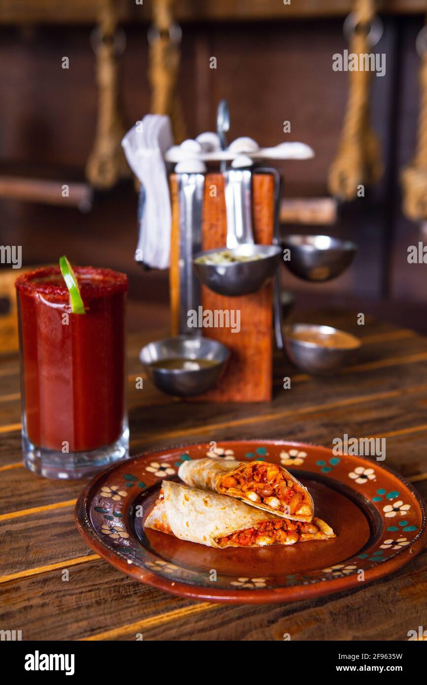 Mexican burrito and michelada beer with tomato juice with copy space