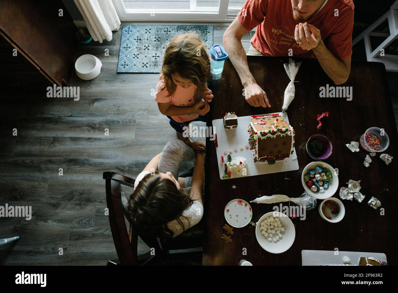 Family making gingerbread houses together at home Stock Photo