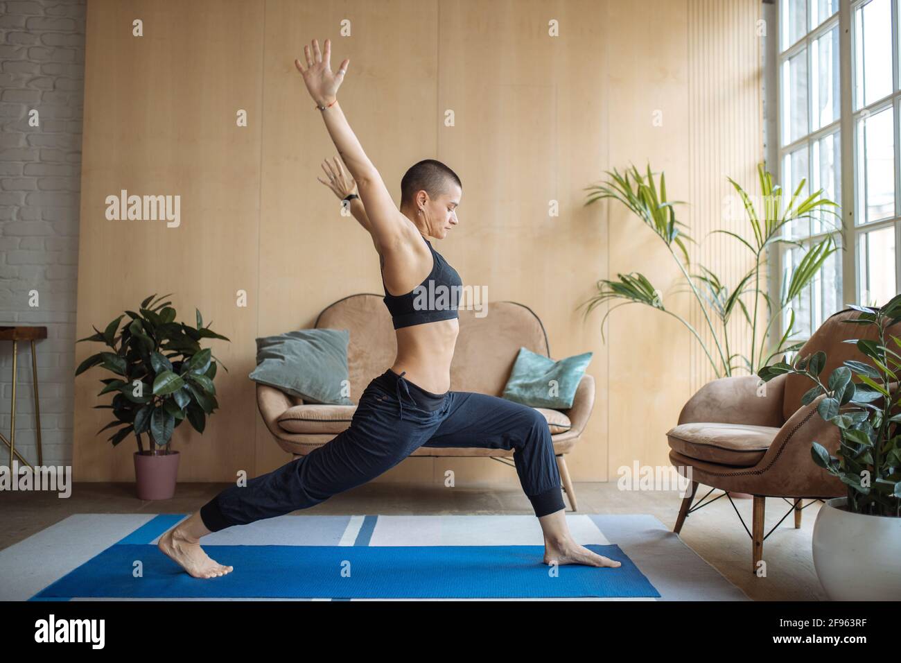 athletic woman doing lunge stretching exercise at home Stock Photo