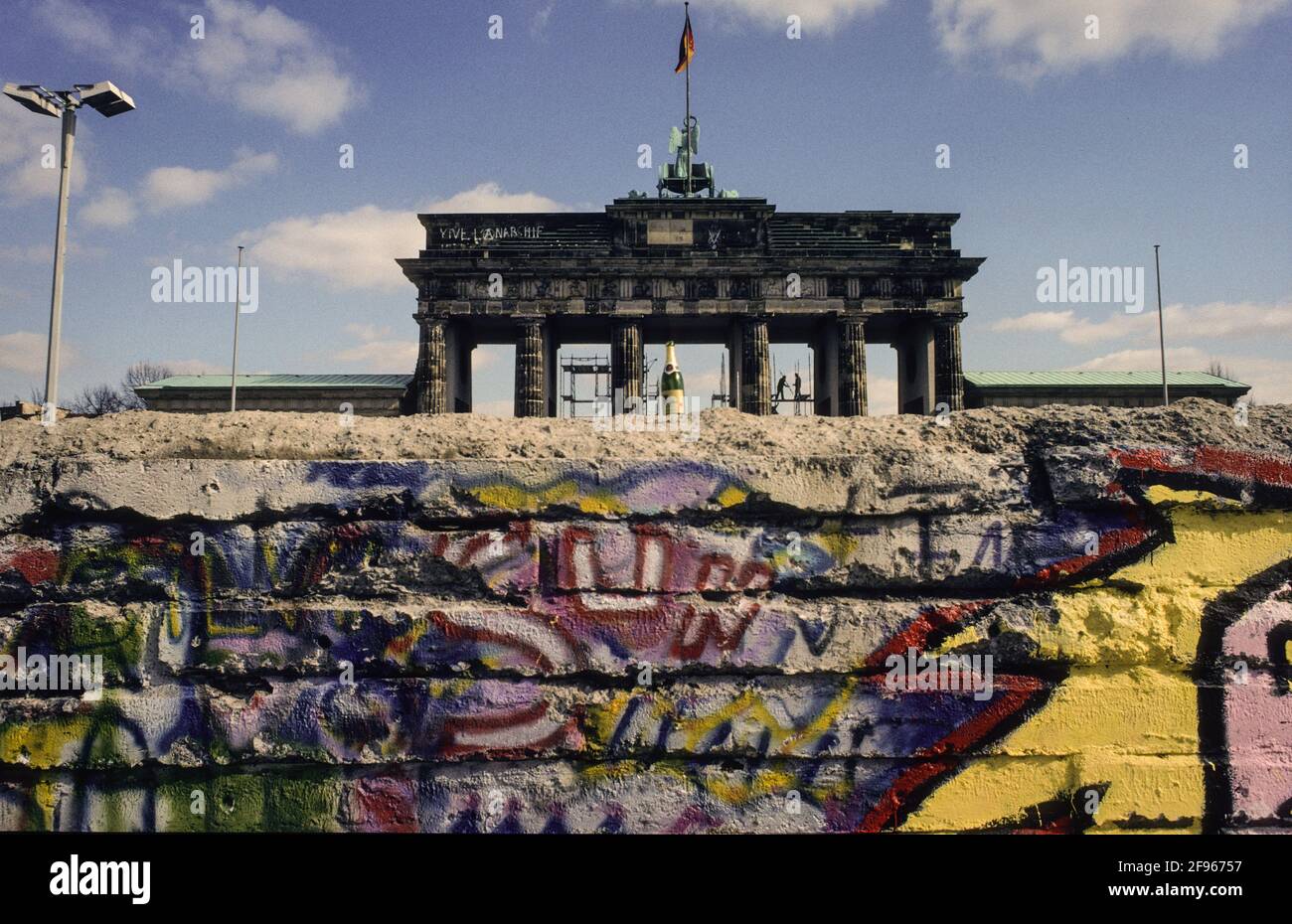 Das Brandenburger Tor hinter den bemalten Resten der Berliner Mauer im Frühjahr 1990 - the Brandenburg Gate behind the painted remains of the Berlin Wall in spring 1990 Stock Photo