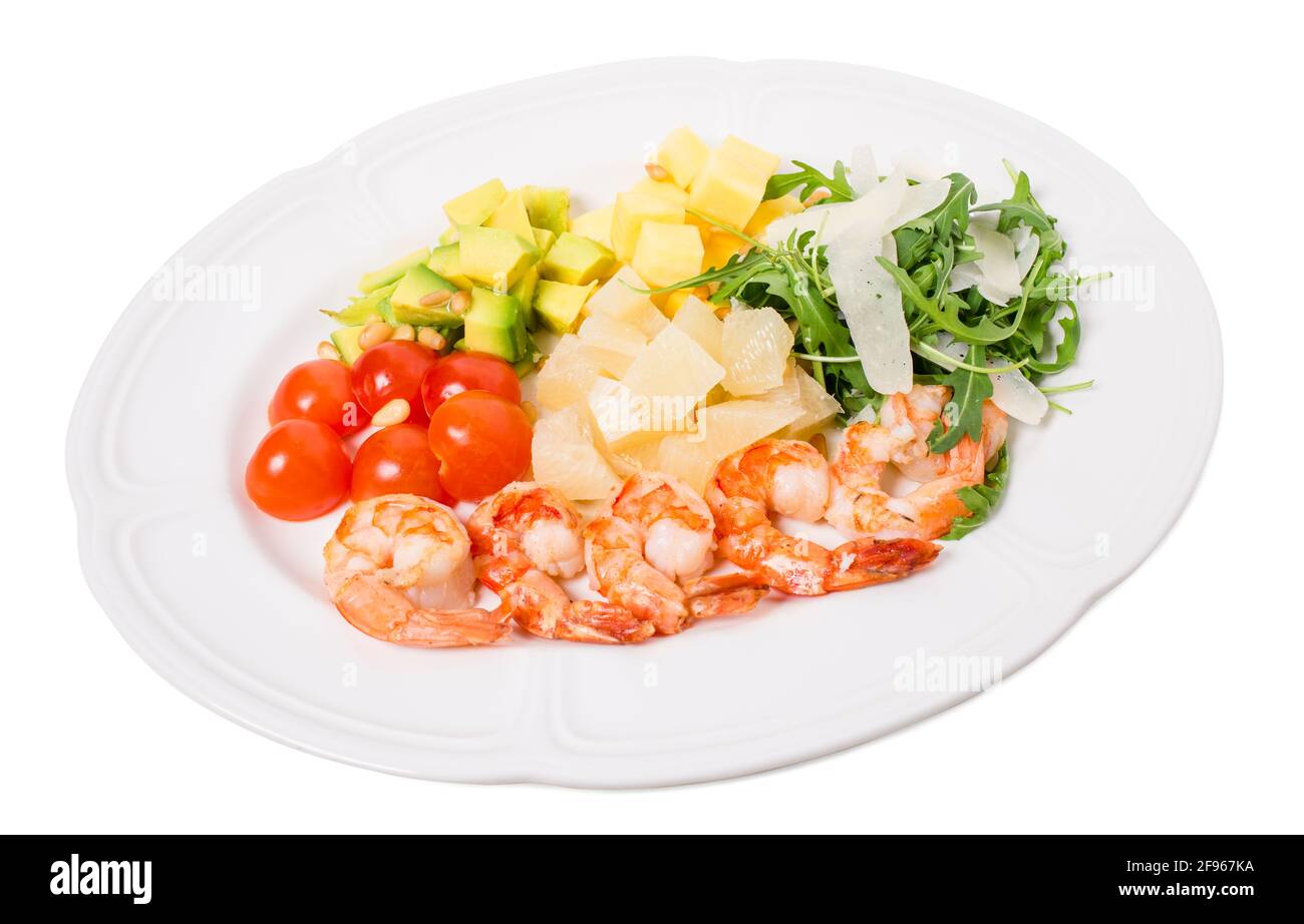 Jumbo shrimp salad with avocado and mango topped with pine nuts and parmesan cheese. Isolated on a white background. Stock Photo