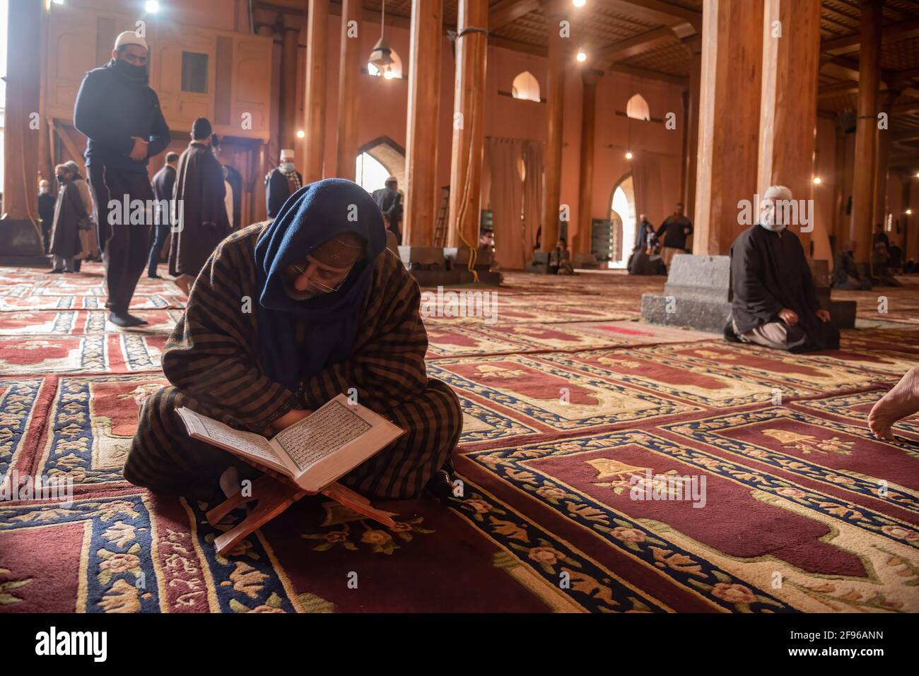 A Kashmiri Muslim reads a Holy Book of Quran on first Friday of ramadan ...