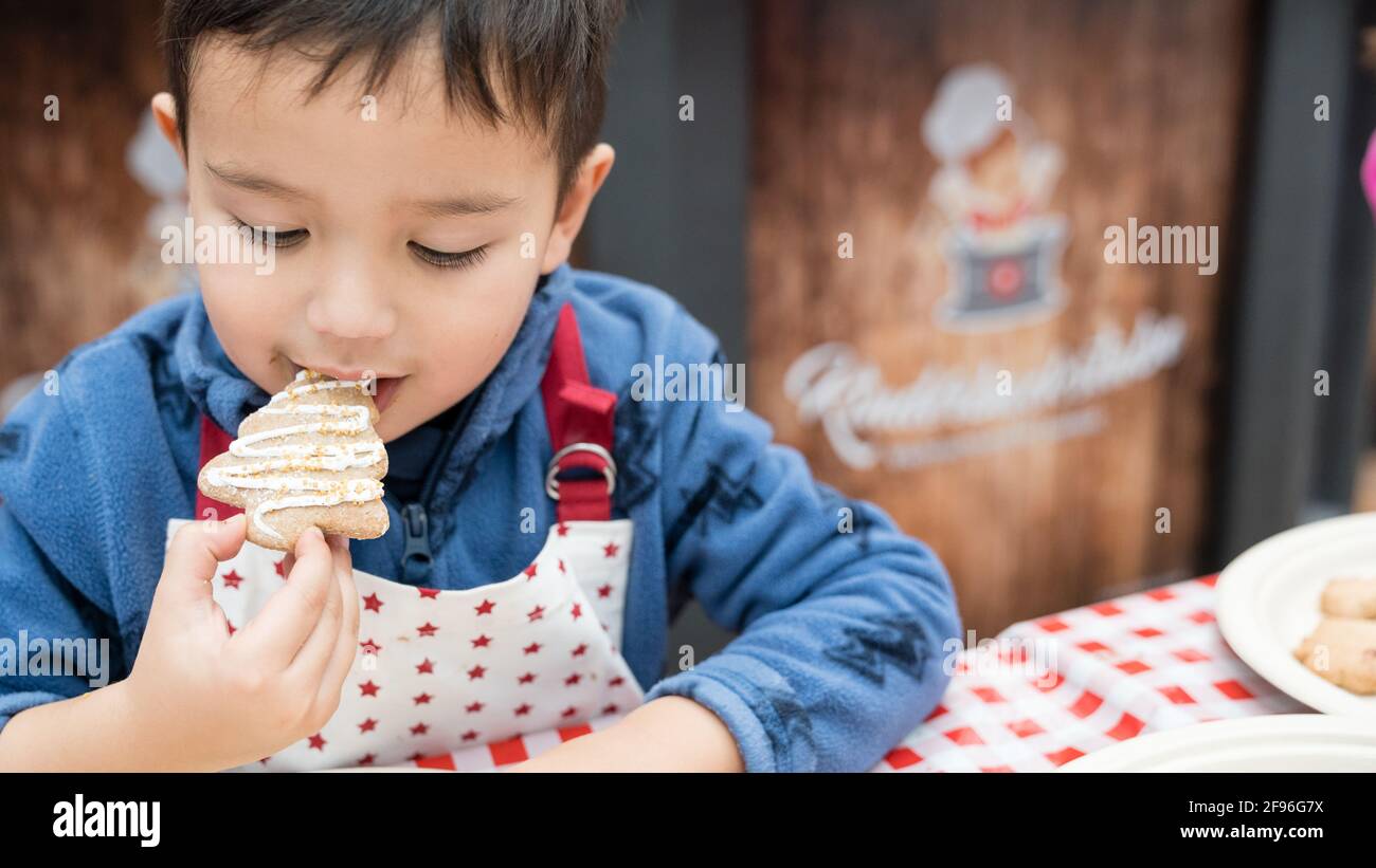 Children baking at Christmas time, children's bakery, boy eating cookie Stock Photo