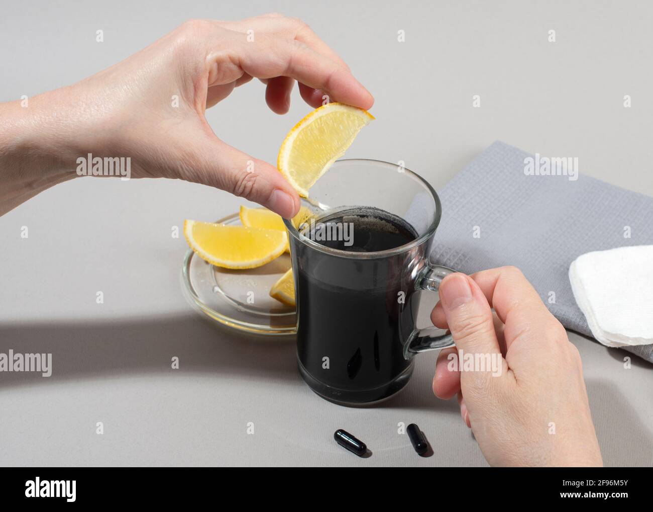Womans hands making detox drink with activated charcoal. Close up. Healthy lifestyle concept. Stock Photo