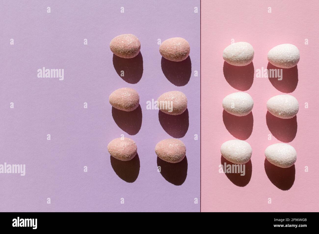 Abstract Easter layout with eggs and trend summer shadows on two tone pastel pink and violet background. Minimal spring holiday concept. Copy space. F Stock Photo