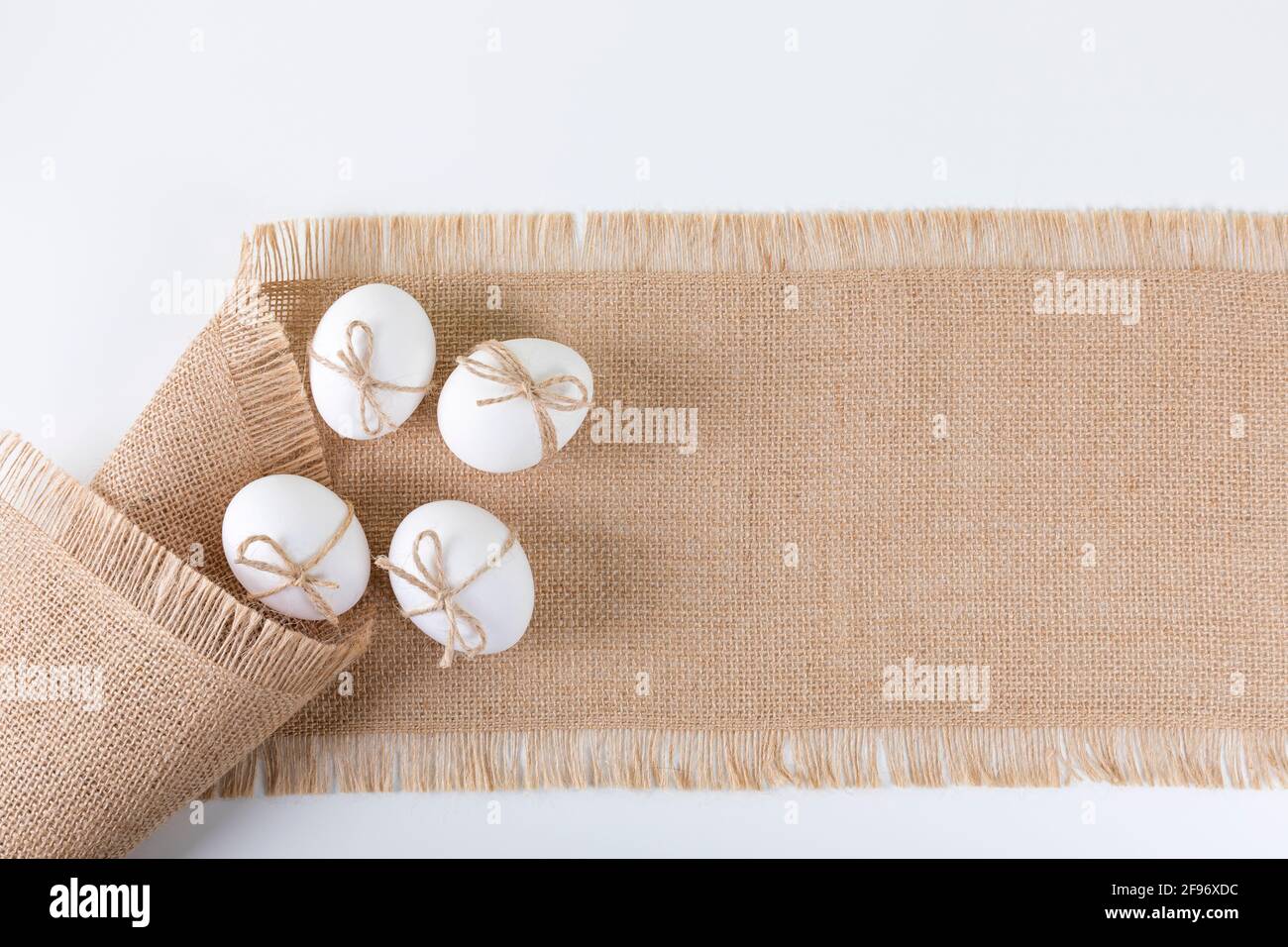 Happy Easter concept. White fresh chicken eggs on linen tablecloth. Simple minimalism. Copy space. Flat lay. Stock Photo