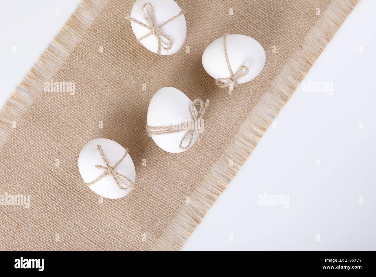 Happy Easter concept. White fresh chicken eggs on linen tablecloth. Simple minimalism. Copy space. Flat lay. Stock Photo