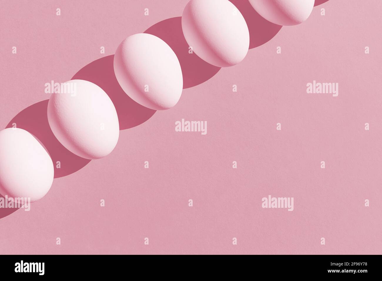 Easter Concept. White fresh eggs in isometric line on pink paper background. Minimal food concept. Copy space. Flat lay. Stock Photo