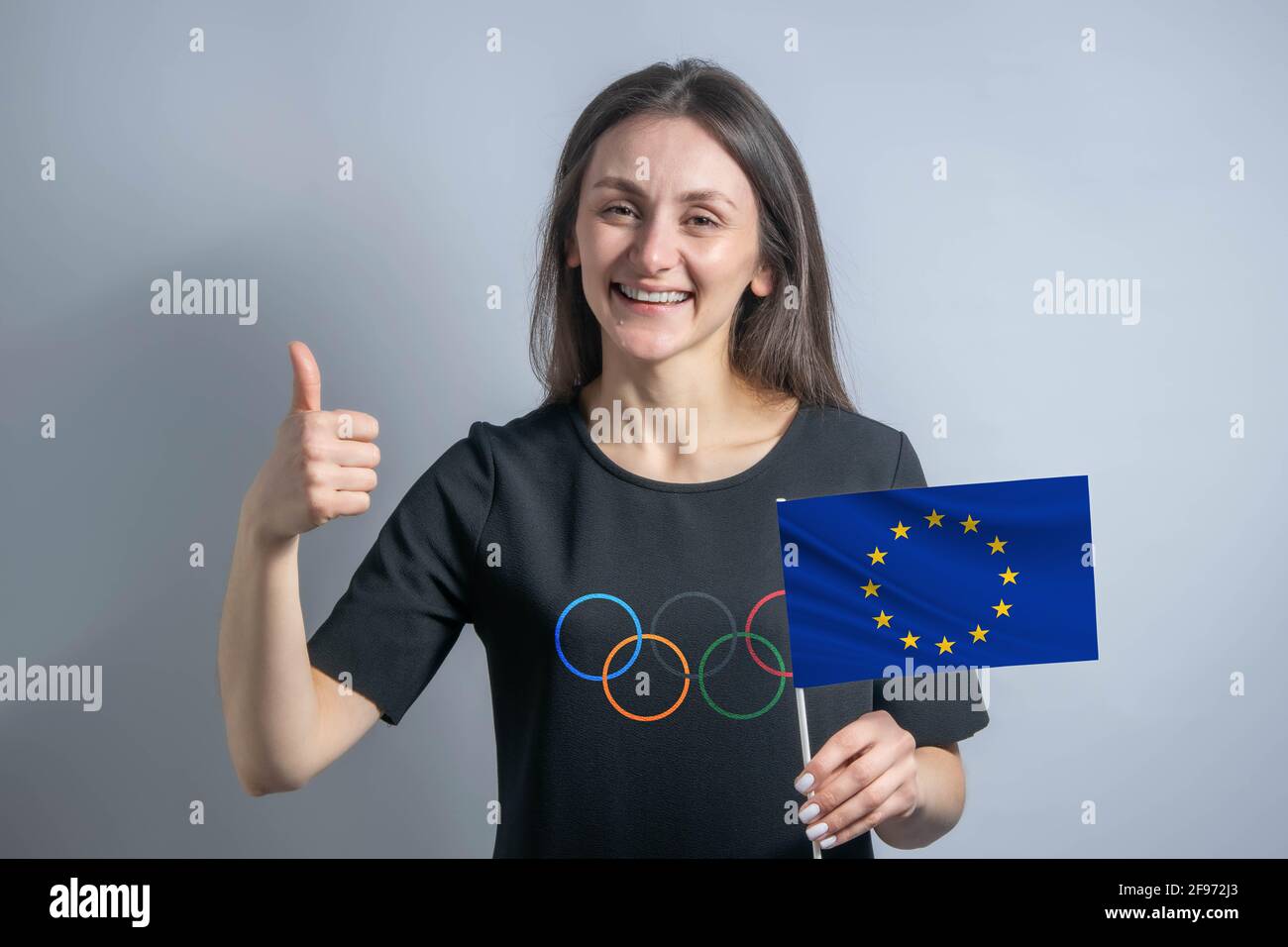 Happy young white woman holding flag of European Union and shows the ...