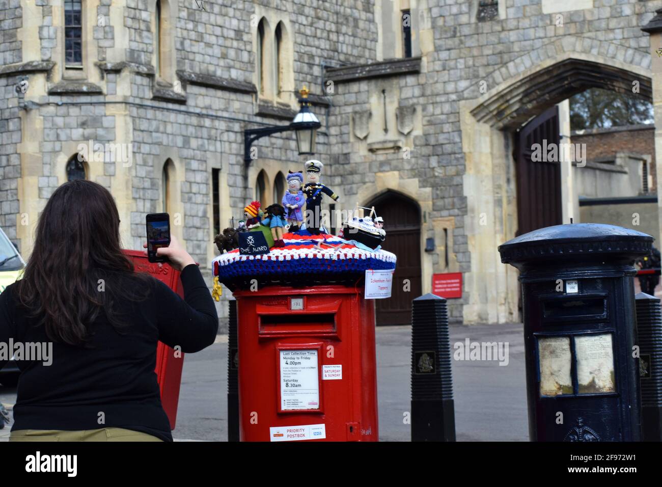 Windsor, UK, 16 April 2020  Ickenham Postbox Toppers, depicting Queen Elizabeth II and her husband Prince Philip, Duke Of Edinburgh on top of  the post box outside Windsor castle. Tributes to Prince Phillip laid outside Windsor Castle. Windsor castle busy with tourists as well as preparations for Prince Phillip, the Duke of Edinburgh funeral. Credit: JOHNNY ARMSTEAD/Alamy Live News Stock Photo