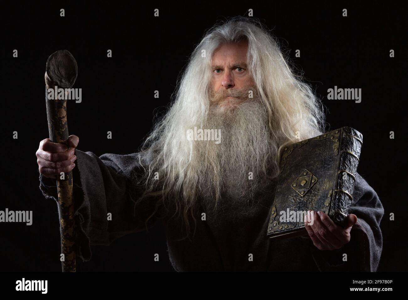A wizard with a magical ancient book of spells Stock Photo
