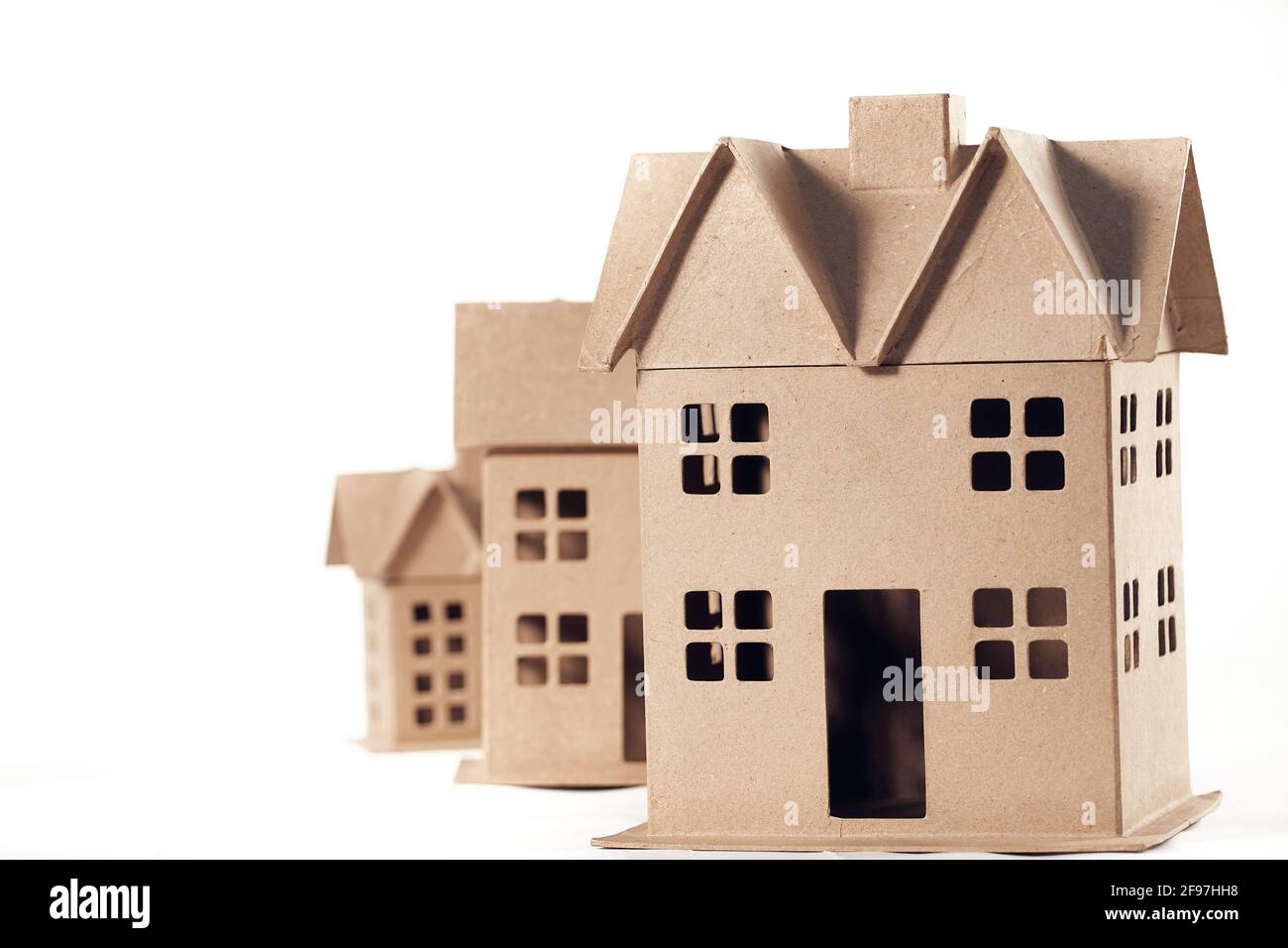 Three houses made of cardboard isolated on white background Stock Photo -  Alamy, image size:1300x956