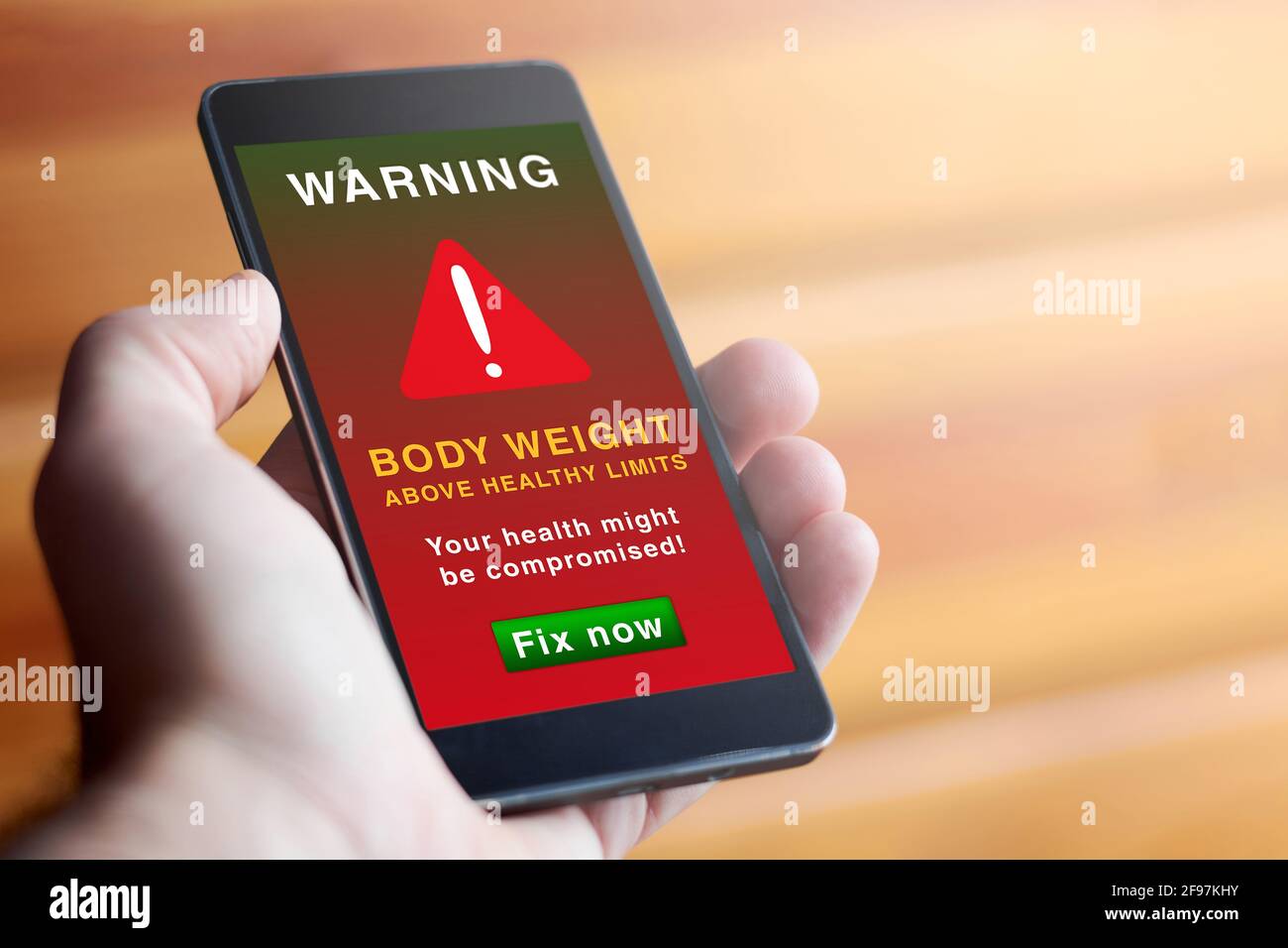Getting Fat Problem Phone Closeup of male hand holding modern mobile phone with red screen and ...