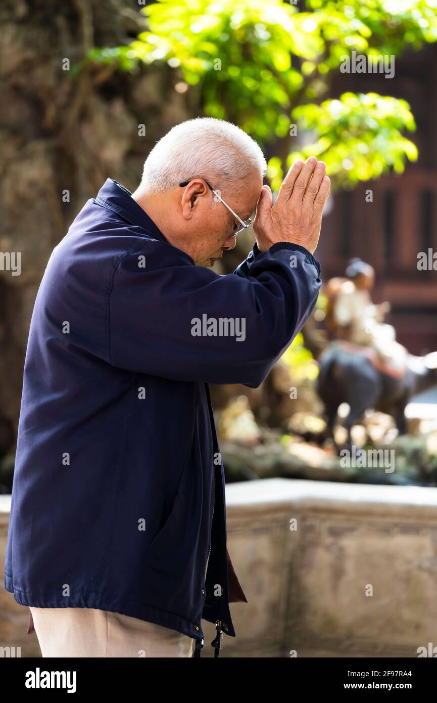 Vietnam, Hanoi, Tran Quoc Pagoda on the West Lake, senior, prayer, sideways Stock Photo