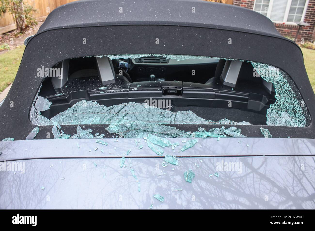 Vandalized soft top convertible sports car with back window smashed out